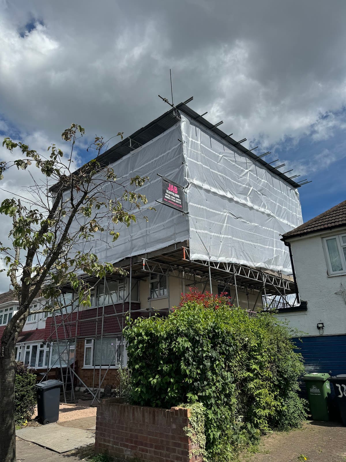 Building wrapped in scaffolding and protective sheeting during renovation